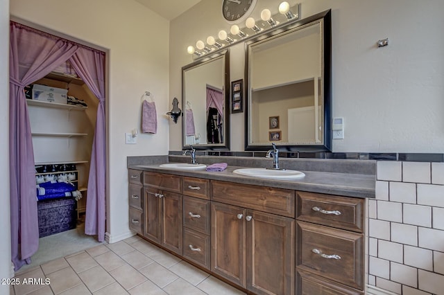 full bathroom featuring double vanity, a sink, and tile patterned floors