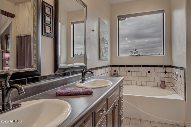 bathroom with a bath, tile patterned flooring, double vanity, and a sink