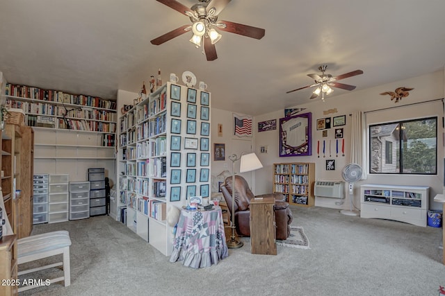 sitting room with carpet, ceiling fan, and a wall mounted air conditioner