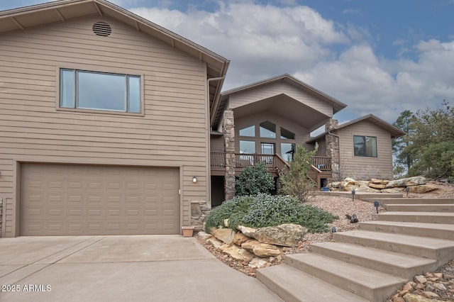 view of front of property featuring a garage, driveway, and stairs