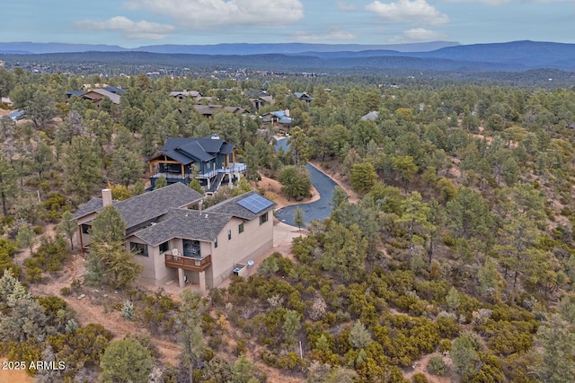 aerial view featuring a forest view and a mountain view