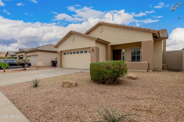 view of front of house with concrete driveway, an attached garage, a tile roof, and stucco siding