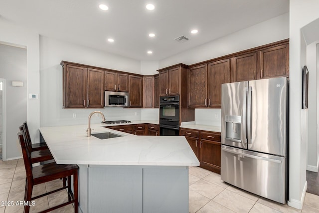 4618 W Pokeberry Ln, Phoenix, AZ 85083 - kitchen with appliances with stainless steel finishes, light tile patterned floors, a peninsula, recessed lighting, and a breakfast bar