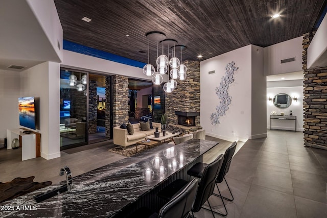 bar with visible vents, wooden ceiling, a fireplace, and a chandelier