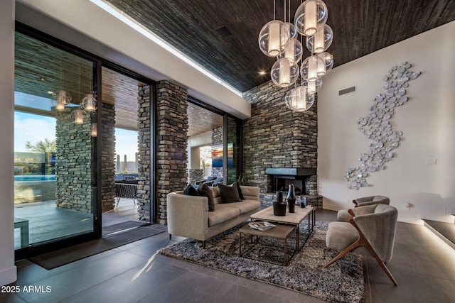 living room with wood ceiling, visible vents, a notable chandelier, and a stone fireplace