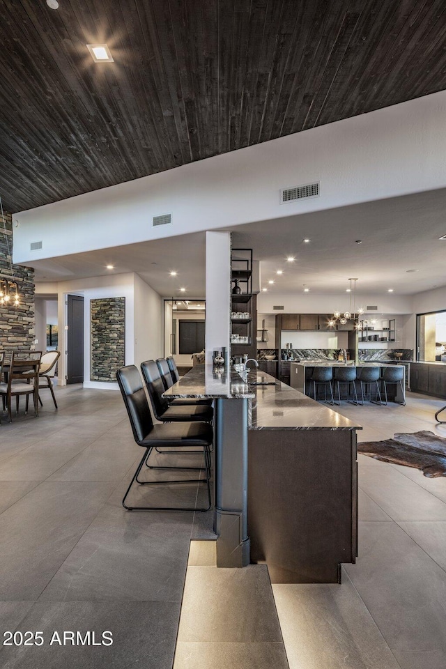 living area with recessed lighting, visible vents, and wood ceiling