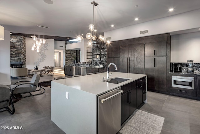 kitchen featuring a sink, open floor plan, appliances with stainless steel finishes, an inviting chandelier, and light countertops