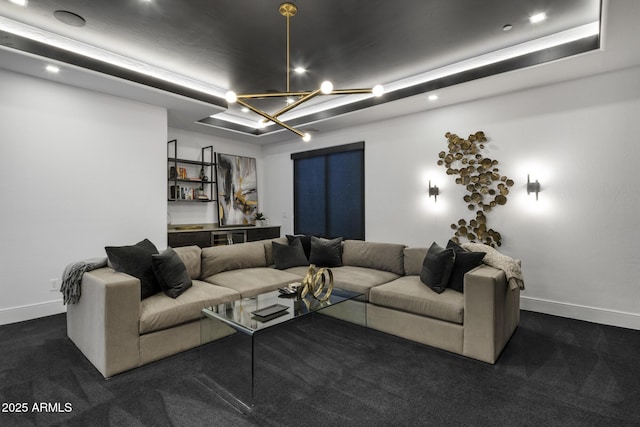 living room with a notable chandelier, baseboards, and dark colored carpet