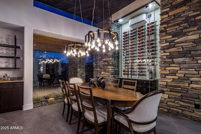 dining space featuring tile patterned flooring, an AC wall unit, and an inviting chandelier