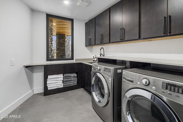 laundry area with visible vents, baseboards, washer and clothes dryer, cabinet space, and a sink