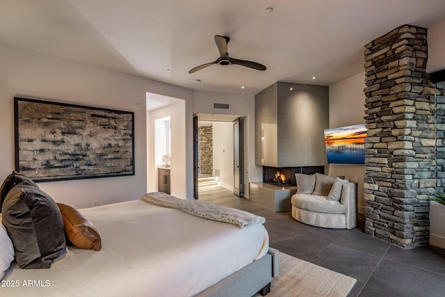 bedroom with ceiling fan, visible vents, a multi sided fireplace, and connected bathroom