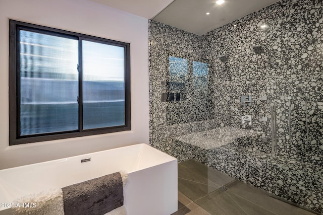 bathroom featuring tile patterned flooring and a freestanding bath