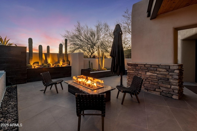 view of patio featuring an outdoor fire pit and fence