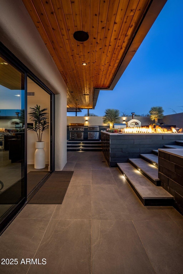 balcony featuring exterior kitchen and a patio