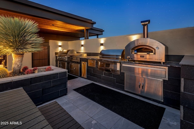 view of patio with an outdoor kitchen and a grill