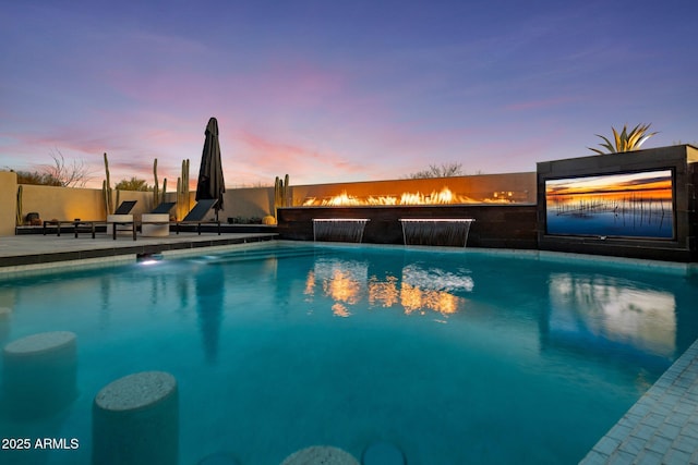 pool at dusk featuring a fenced in pool and a patio