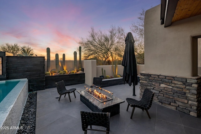 view of patio featuring a fenced in pool, a fenced backyard, and an outdoor fire pit