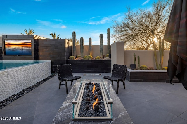 view of patio / terrace featuring fence, a fenced in pool, and an outdoor fire pit