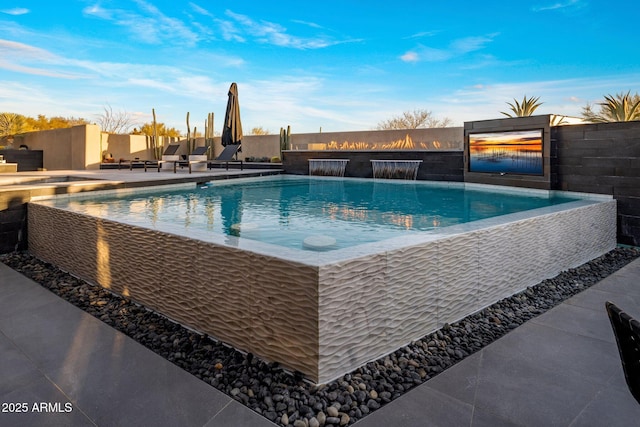 view of swimming pool with a patio, an infinity pool, and fence