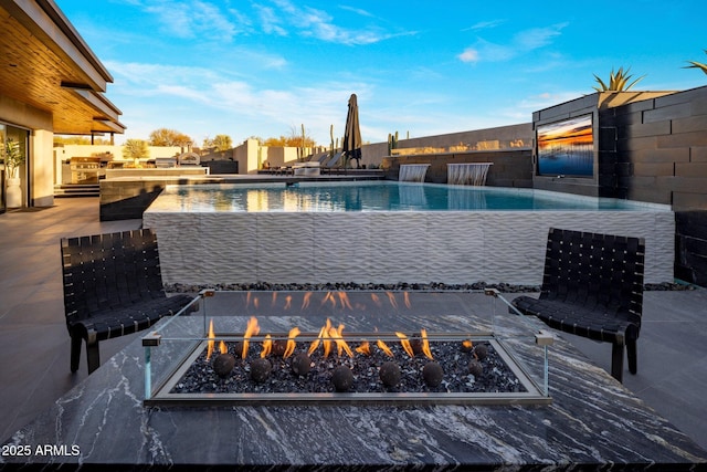 pool with area for grilling and an outdoor fire pit