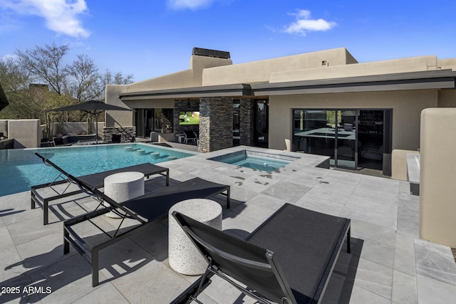 outdoor pool featuring an in ground hot tub, a fireplace, and a patio