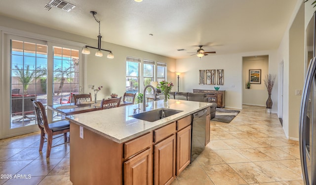 kitchen featuring visible vents, dishwasher, light stone countertops, pendant lighting, and a sink