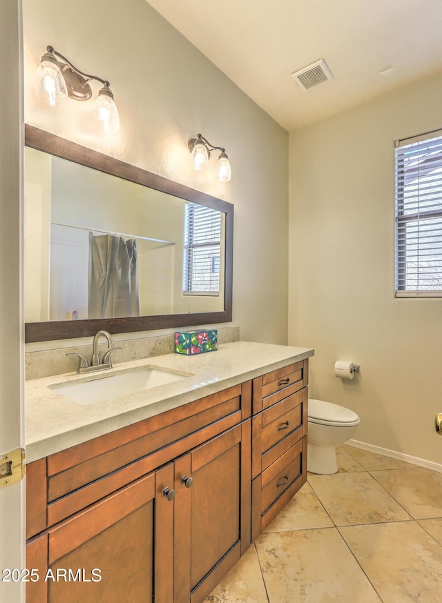 bathroom with toilet, vanity, visible vents, baseboards, and tile patterned floors