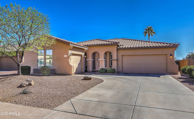 mediterranean / spanish house with a garage, concrete driveway, and stucco siding