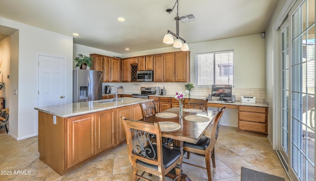 kitchen with backsplash, visible vents, stainless steel appliances, and a sink