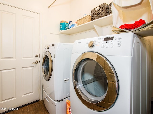 clothes washing area featuring dark wood-type flooring, washer and dryer, and laundry area