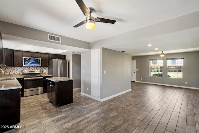 6743 S Jentilly Ln, Tempe, AZ 85283 - kitchen with visible vents, open floor plan, ceiling fan, a sink, and stainless steel appliances