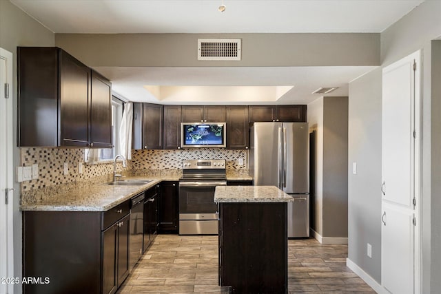 6743 S Jentilly Ln, Tempe, AZ 85283 - kitchen featuring visible vents, a sink, dark brown cabinetry, and stainless steel appliances