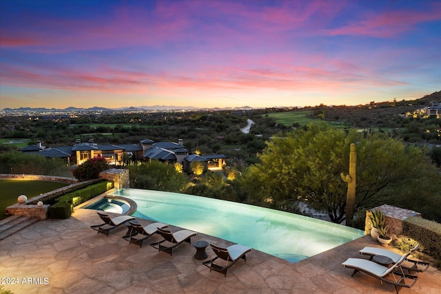 pool at dusk with a patio area