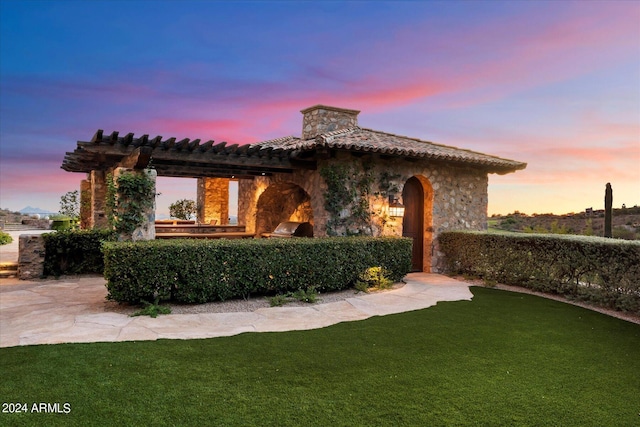 mediterranean / spanish-style home with a lawn and a patio