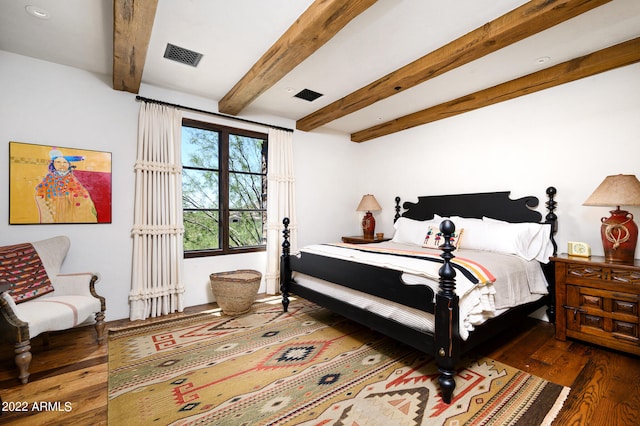 bedroom with beamed ceiling and hardwood / wood-style floors