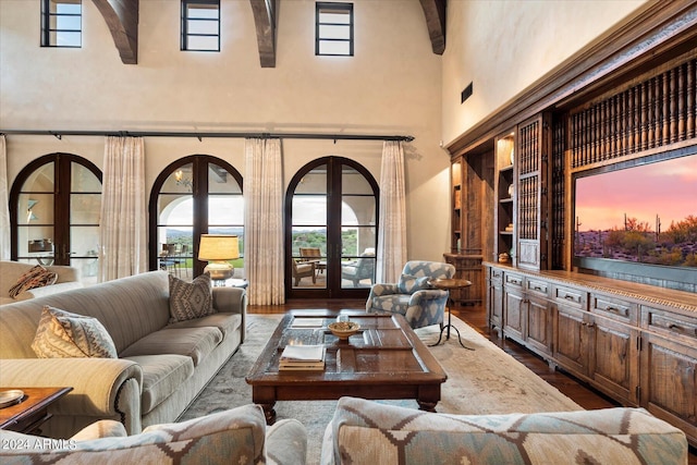 living room with a high ceiling, wood-type flooring, and french doors