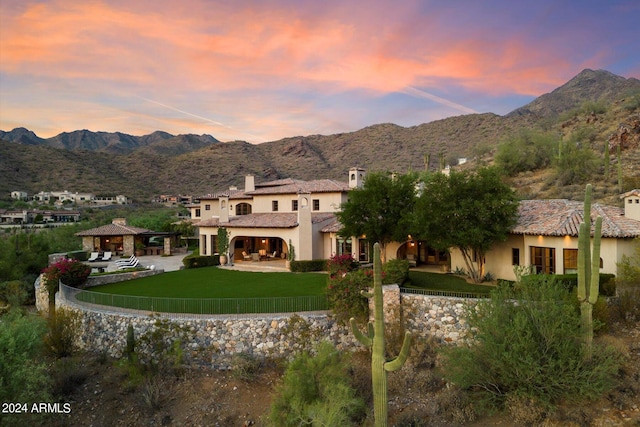 back house at dusk with a mountain view and a gazebo