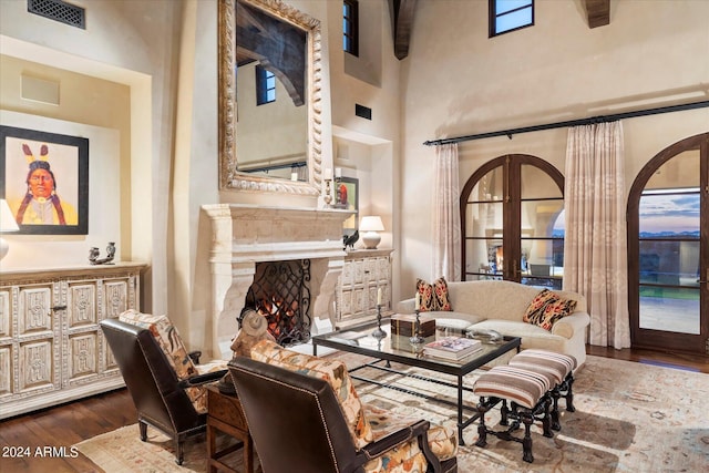 living room with a towering ceiling, french doors, and hardwood / wood-style floors