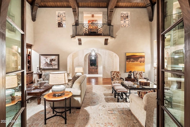 interior space featuring wooden ceiling, hardwood / wood-style floors, beam ceiling, and a high ceiling