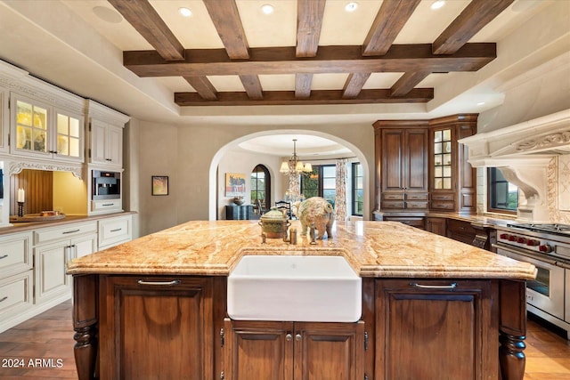 kitchen with a kitchen island, dark hardwood / wood-style floors, and beamed ceiling