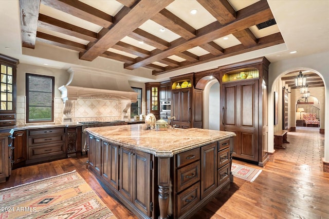 kitchen featuring coffered ceiling, a center island, decorative backsplash, and dark hardwood / wood-style floors