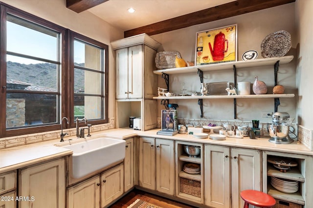 kitchen featuring beamed ceiling and sink