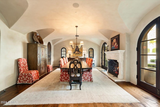 dining room with lofted ceiling, hardwood / wood-style flooring, and a chandelier