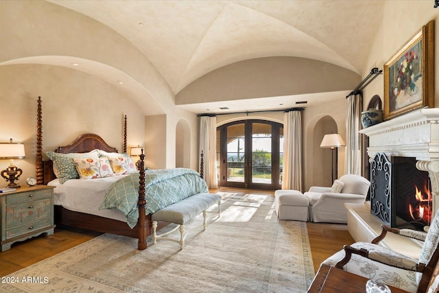 bedroom with lofted ceiling, access to exterior, and light wood-type flooring