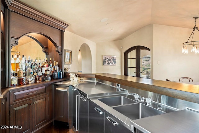 interior space featuring lofted ceiling, dark wood-type flooring, decorative light fixtures, and sink