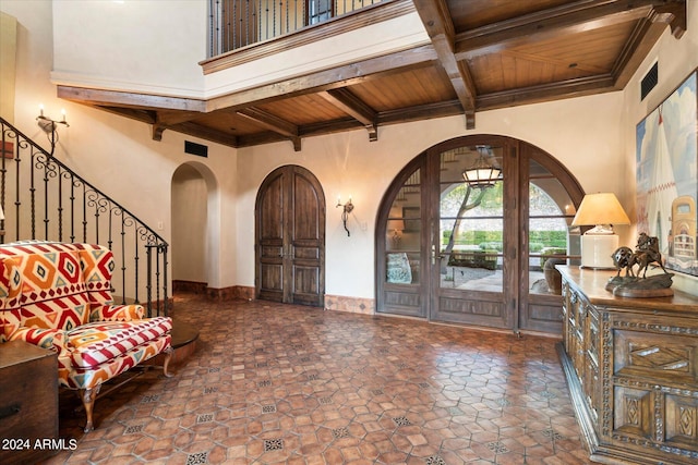 entryway featuring a high ceiling, beam ceiling, and wooden ceiling