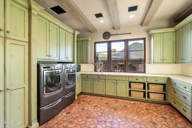 washroom with cabinets, washer and clothes dryer, and sink