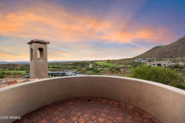 balcony at dusk featuring a mountain view