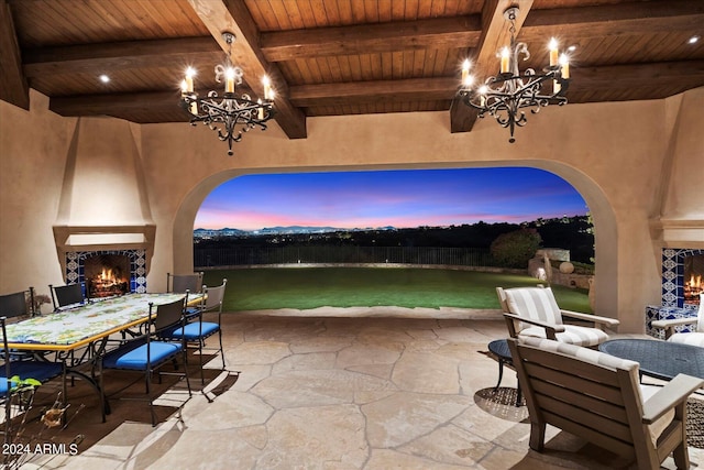 patio terrace at dusk featuring a large fireplace