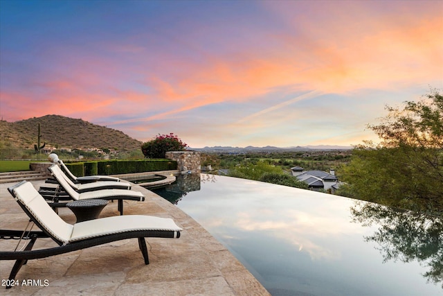 patio terrace at dusk featuring a mountain view